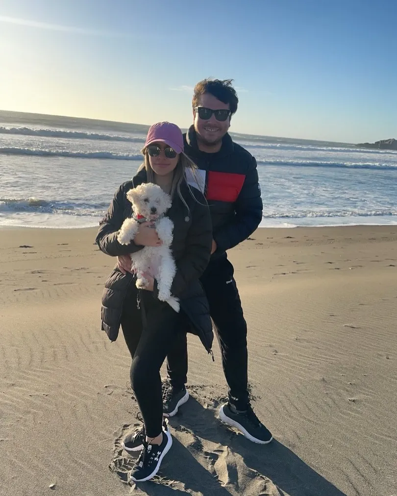 Yanko con su pareja y su perro en la playa al atardecer