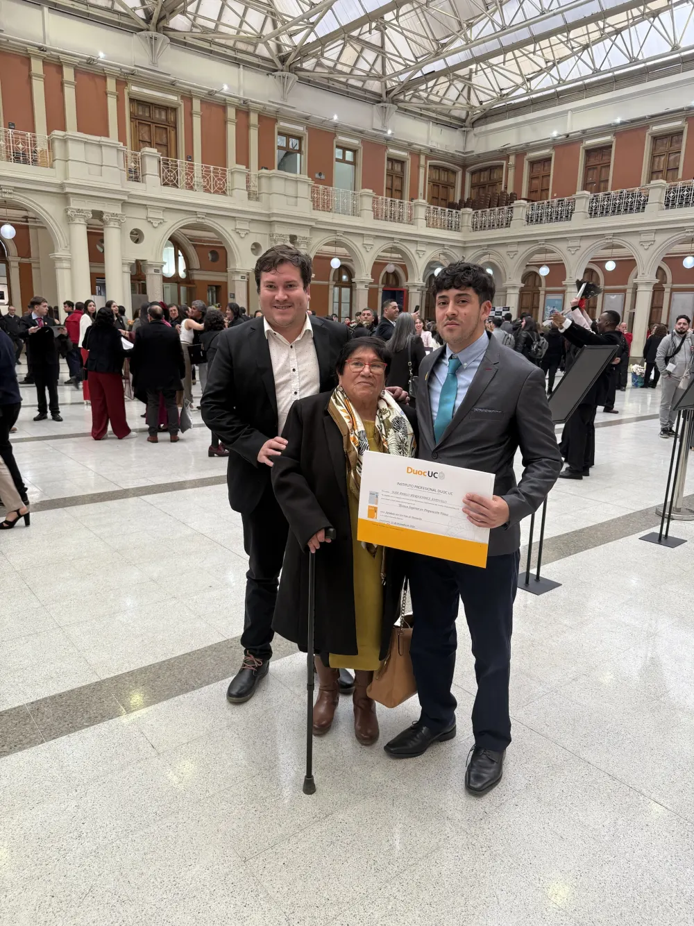 Yanko en una ceremonia de titulación junto a su mamá, Elena Antivilo, y un joven con su diploma